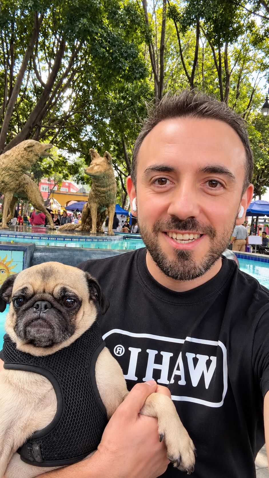 Emma en brazos de su humano frente a la fuente de los Coyotes